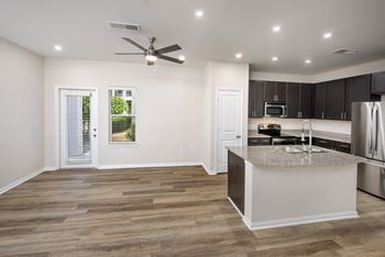 A kitchen with a large island and a ceiling fan.